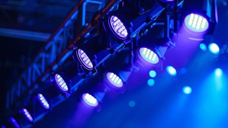 Professional stage lighting setup with blue and purple LED spotlights.